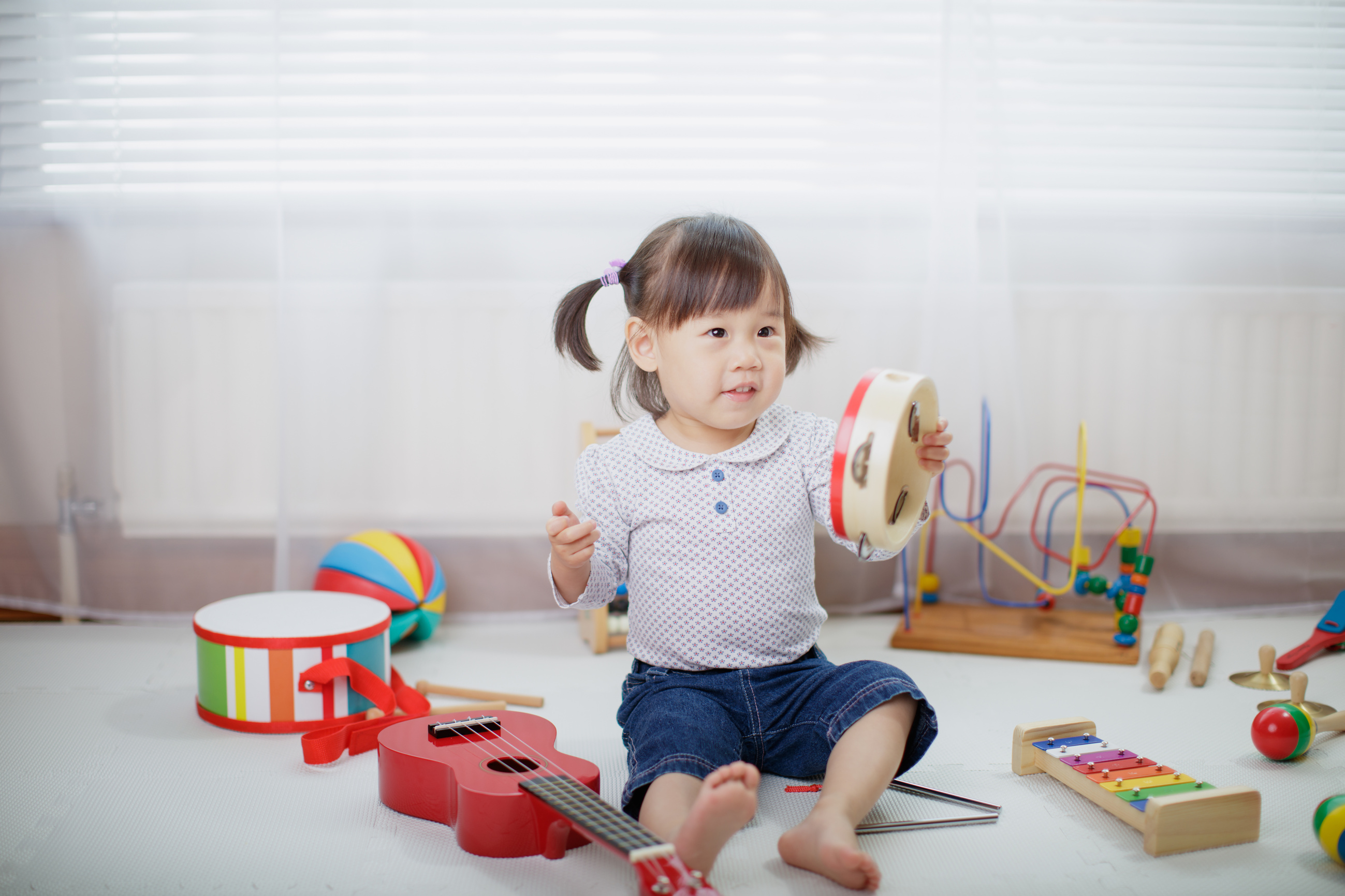 baby girl play tambourine at home