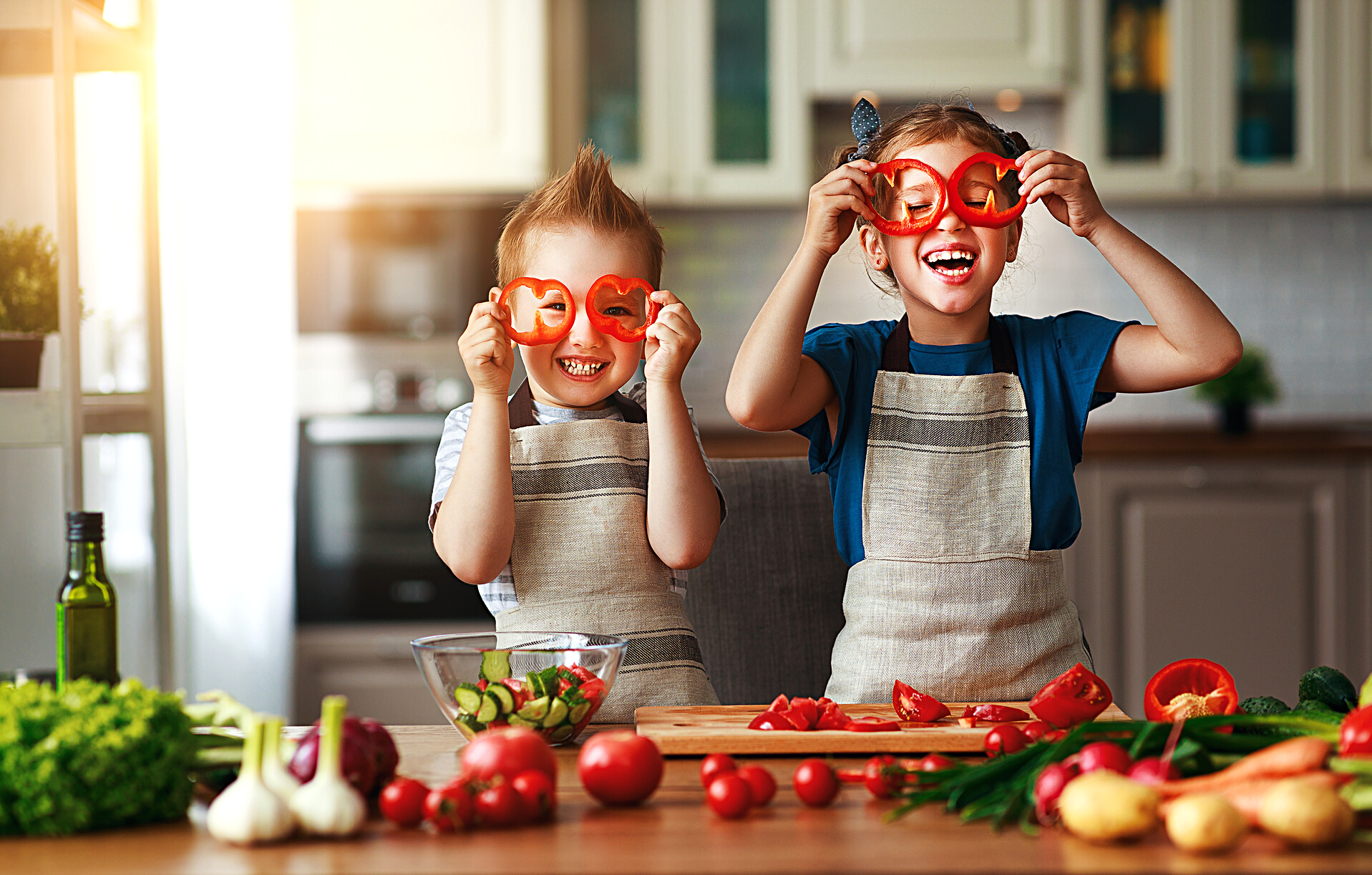 Healthy eating. Happy children prepares  vegetable salad in kitchen